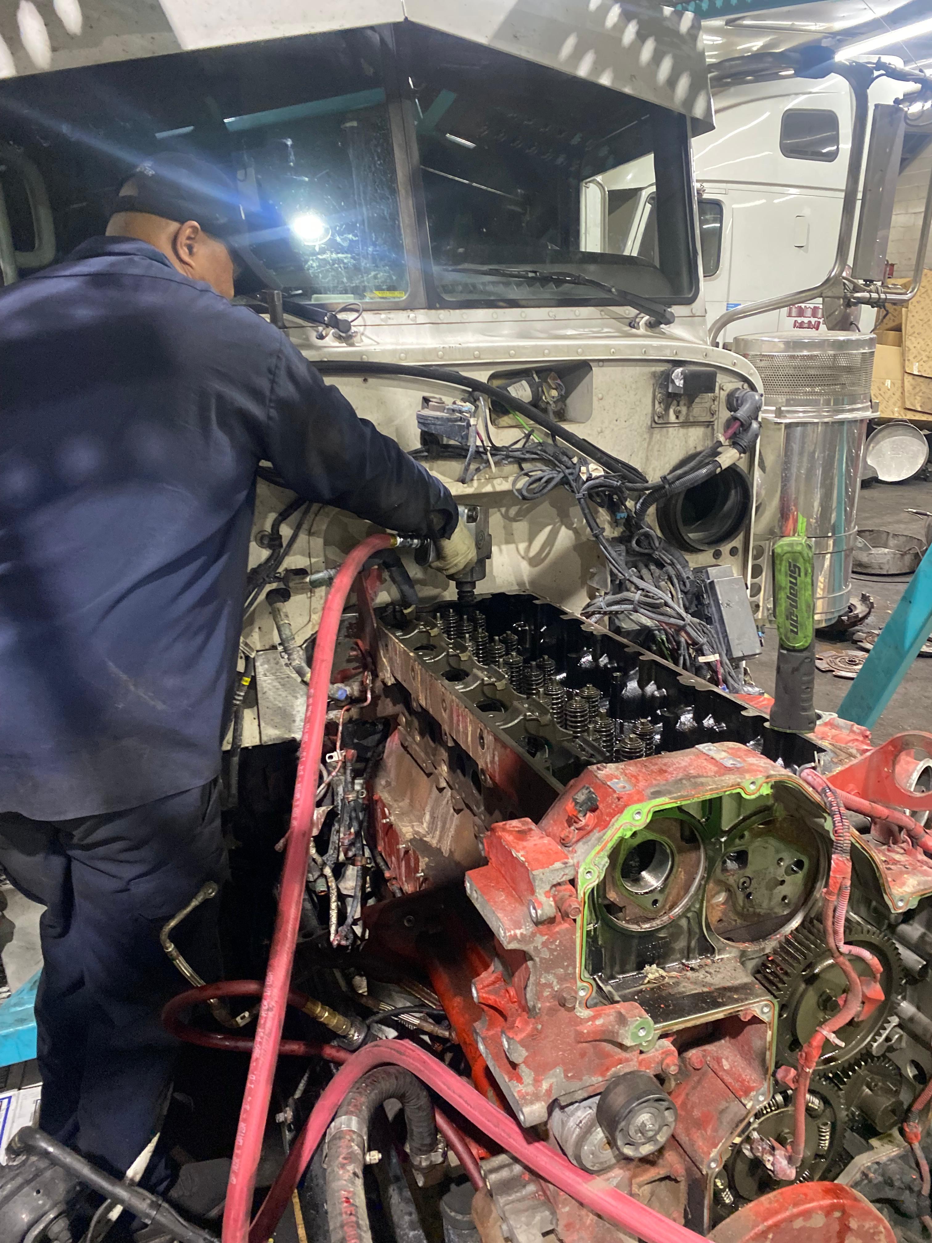 Technician working on a heavy-duty truck engine at Somet Truck Center